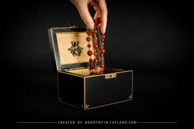 Black wooden jewellery box with a hand-painted golden flower on the lid and a golden bee inside, featuring antique bronze fittings.