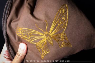 Dorothy in Catland - Brown sachet bag with a yellow butterfly