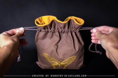 Dorothy in Catland - Brown sachet bag with a yellow butterfly