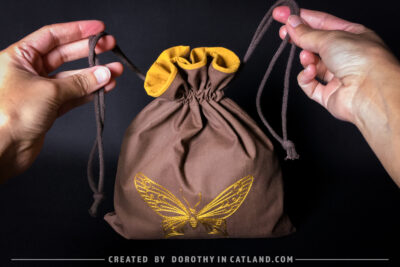 Dorothy in Catland - Brown sachet bag with a yellow butterfly
