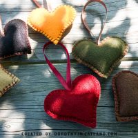 Six felt hearts in autumn colors lying flat, handmade decorations