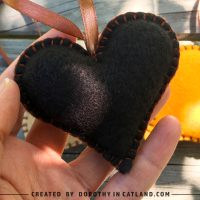 Close-up of a handmade black felt heart with hanging loop