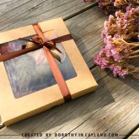 Autumn felt hearts gift set in a kraft box tied with a ribbon, surrounded by dried flowers.