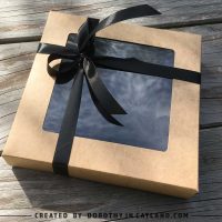 Halloween felt heart ornaments in a kraft box tied with a black ribbon.