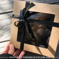 Set of handmade black felt hearts packed in a grey kraft box with a black ribbon.